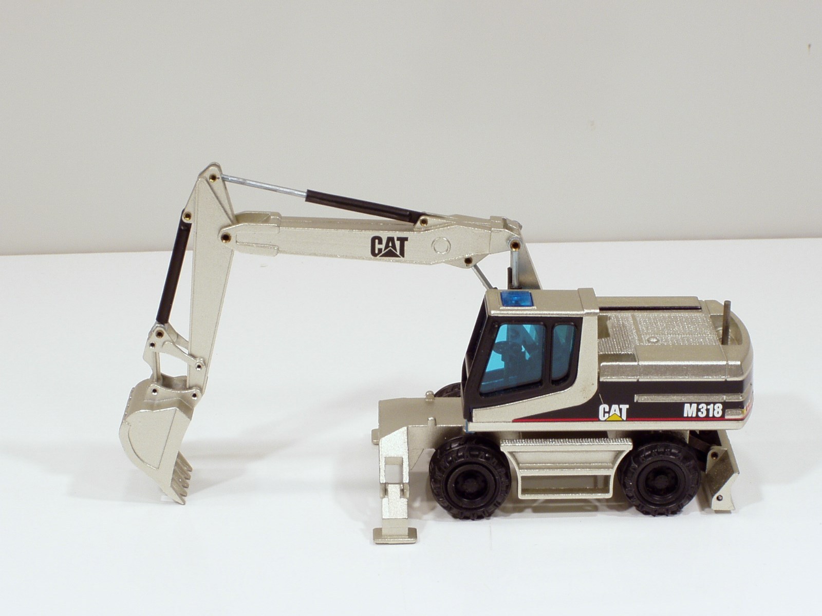 Caterpillar M318 Wheel Excavator – “PALE GOLD” – 1/50 – NZG #405.02 – MIB