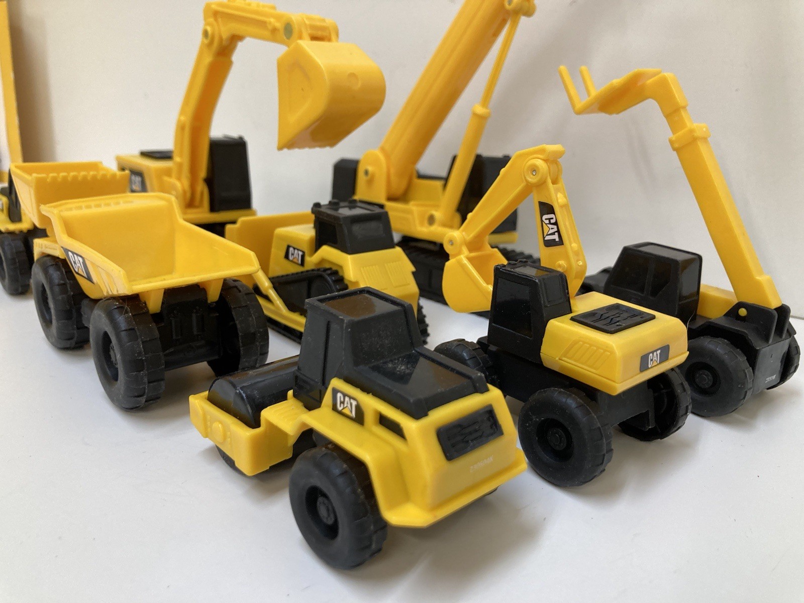 8 Small 3”-4” Long Plastic Toy Caterpillar Construction Trucks. Movable Parts