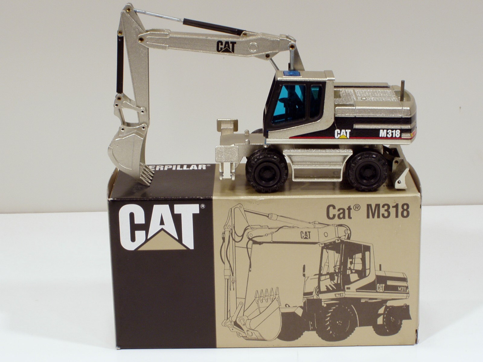 Caterpillar M318 Wheel Excavator – “PALE GOLD” – 1/50 – NZG #405.02 – MIB