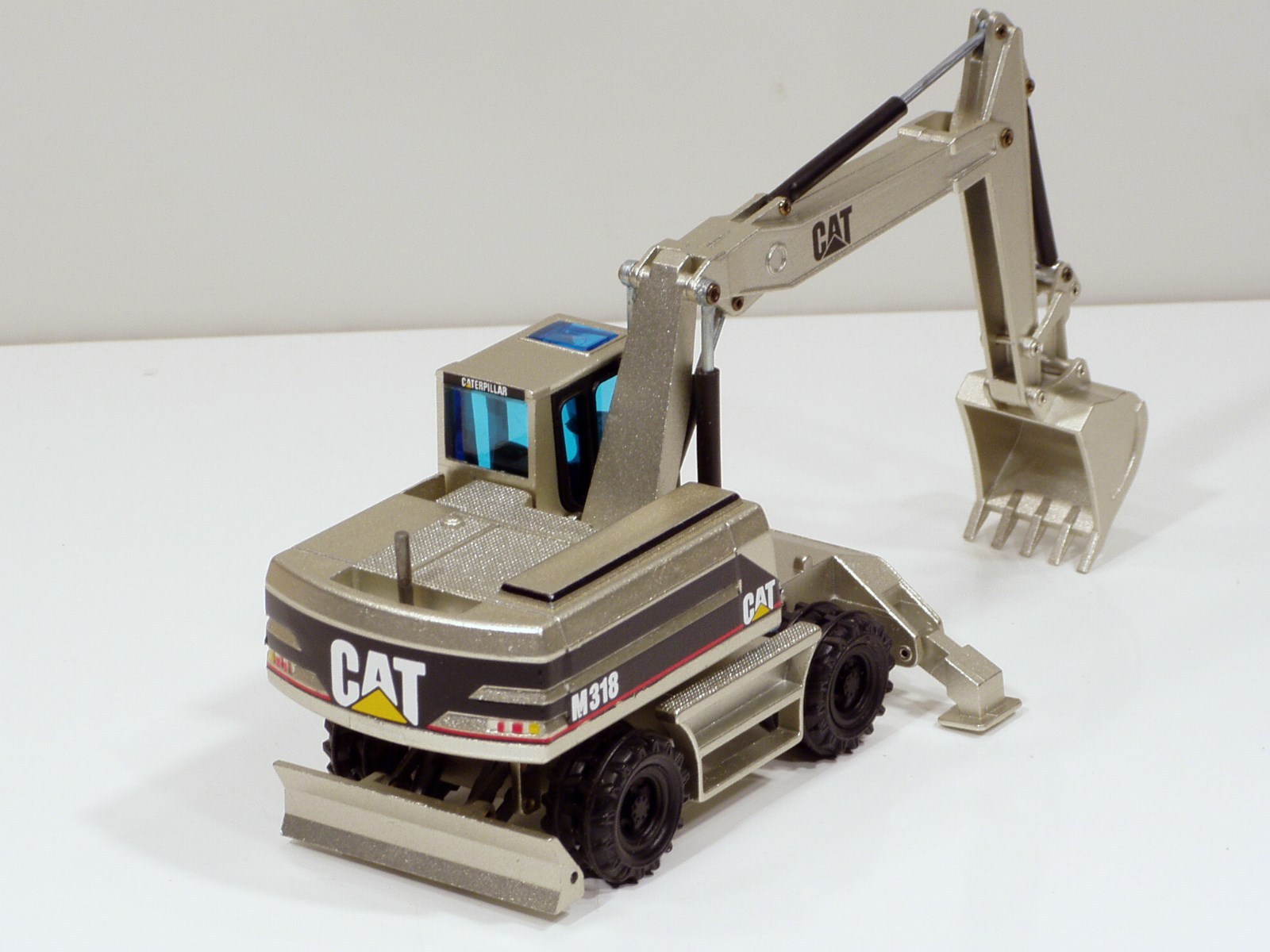 Caterpillar M318 Wheel Excavator – “PALE GOLD” – 1/50 – NZG #405.02 – MIB